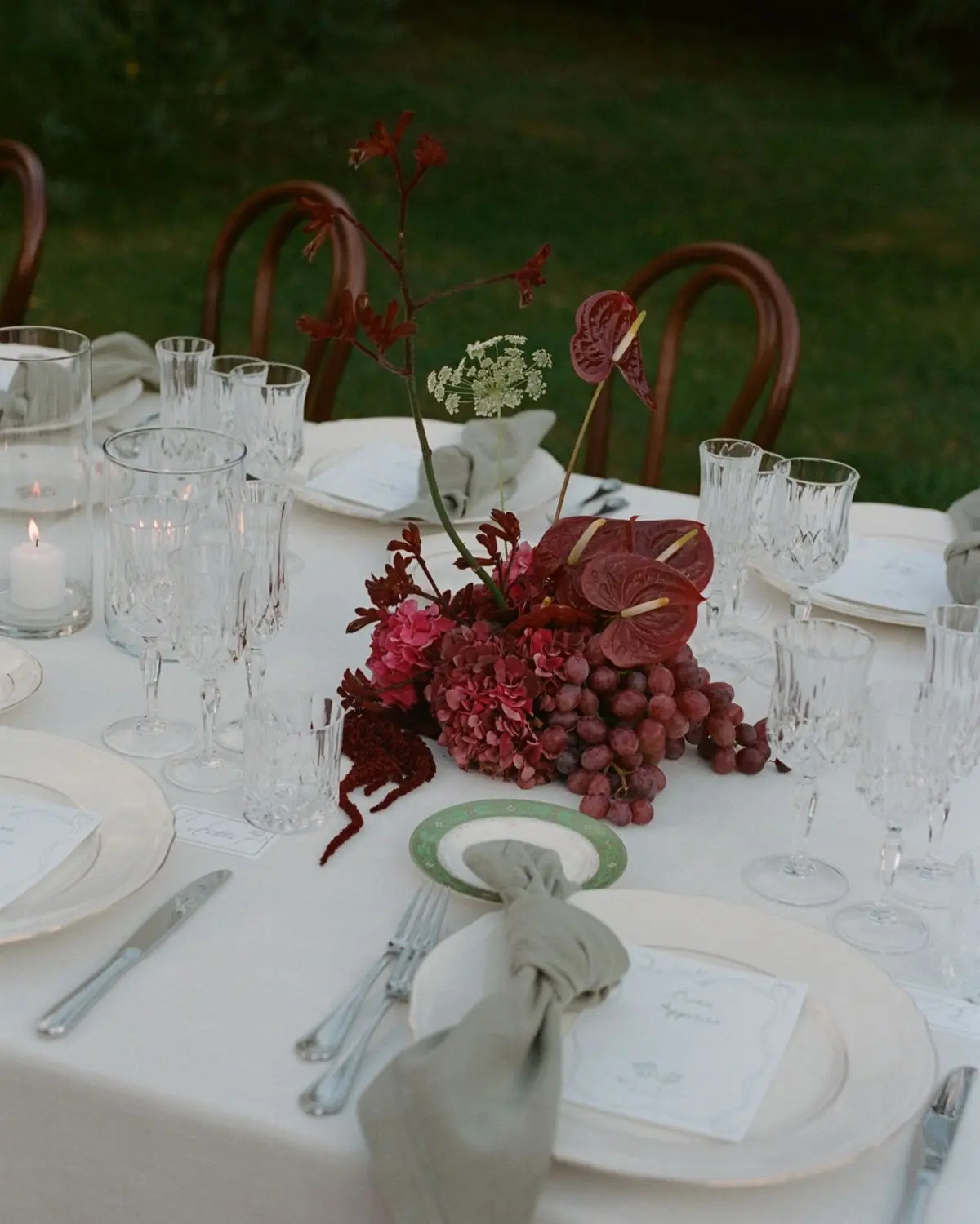 Composition florale automnale rouge et bordeaux sur table – Poppy & Daisy