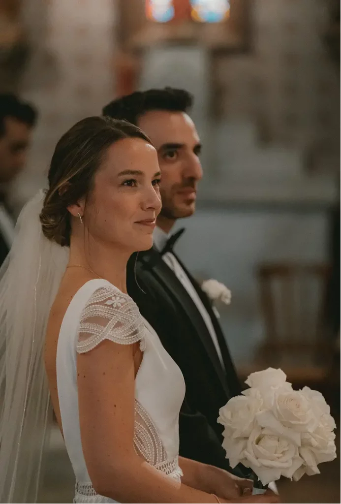 Mariée tenant un bouquet de roses blanches à ruban de satin