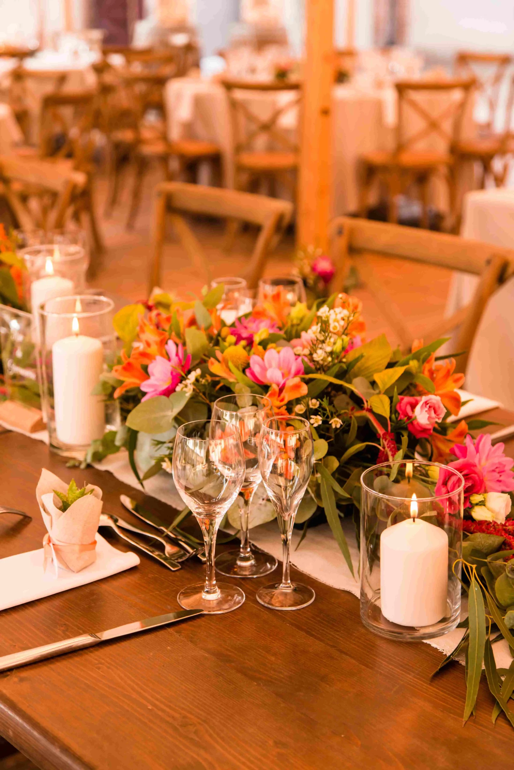 Composition florale longue et basse sur table pour mariage, favorisant la conversation des invités – Poppy & Daisy